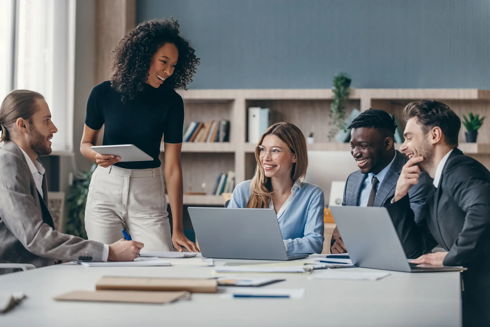 Equipe reunida em volta de uma mesa com notebooks